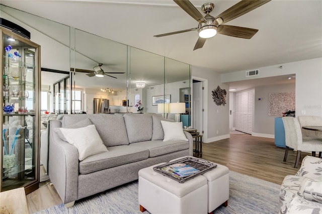 living room featuring ceiling fan and hardwood / wood-style floors