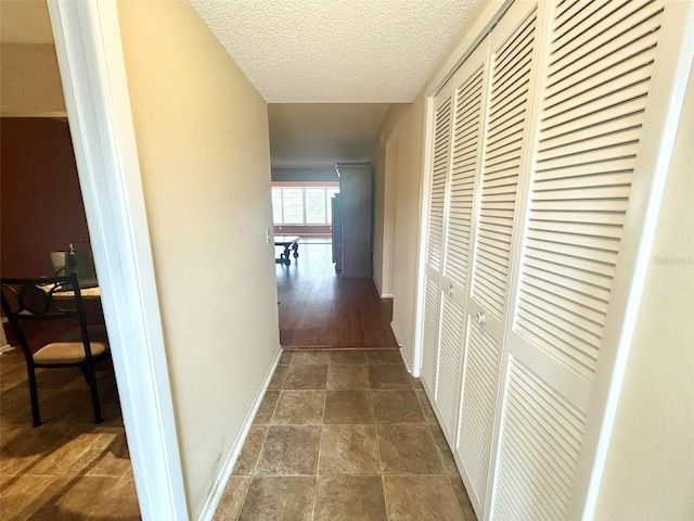 hall with a textured ceiling