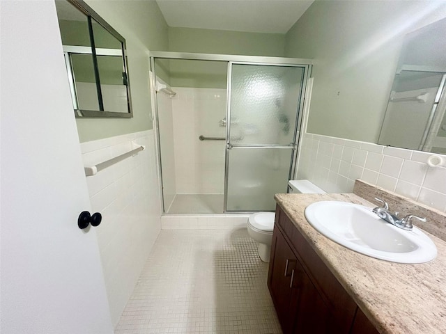 bathroom with a shower with shower door, tile walls, toilet, and tile patterned floors