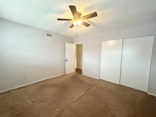 unfurnished bedroom featuring a closet, visible vents, a textured ceiling, and carpet flooring