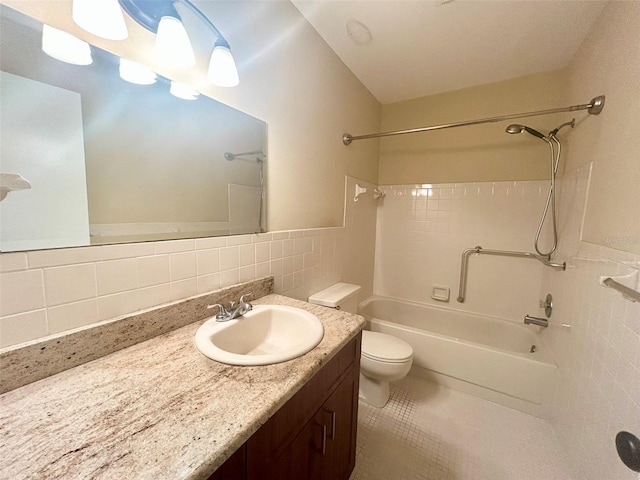 bathroom with toilet, vanity, tile walls, and shower / bathing tub combination