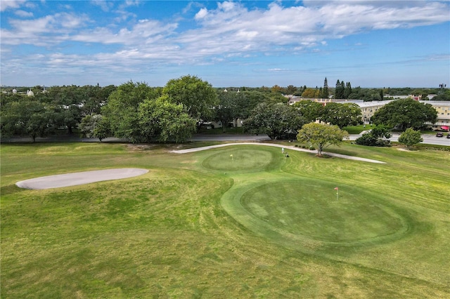 surrounding community with golf course view and a yard