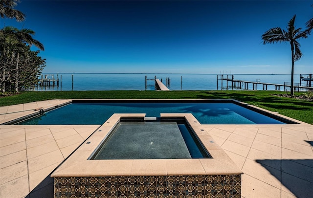 view of swimming pool featuring a lawn, a water view, fence, and a pool with connected hot tub