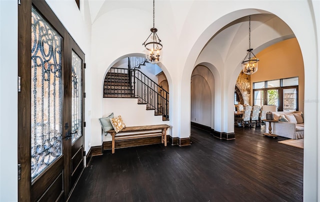 entryway with french doors, a notable chandelier, and wood finished floors