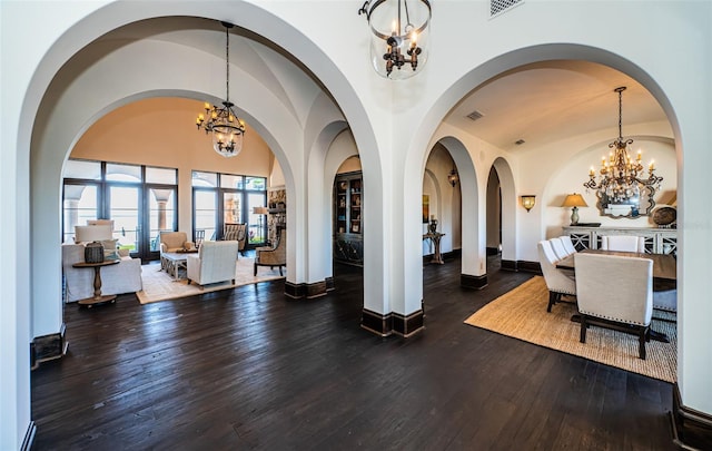 dining space featuring visible vents, an inviting chandelier, vaulted ceiling, wood finished floors, and baseboards