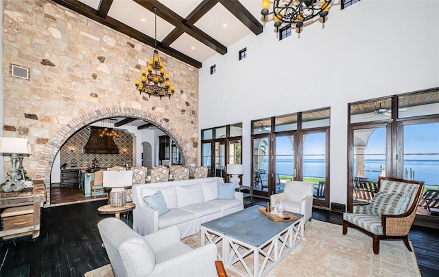 living room with a water view, wood finished floors, and a notable chandelier