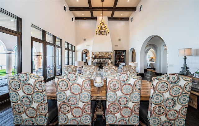 dining room featuring beam ceiling, a notable chandelier, a fireplace, visible vents, and coffered ceiling