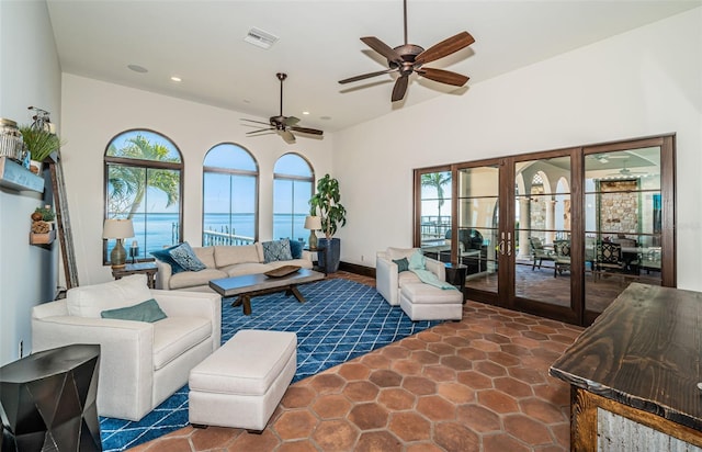 living area with french doors, a water view, visible vents, and recessed lighting