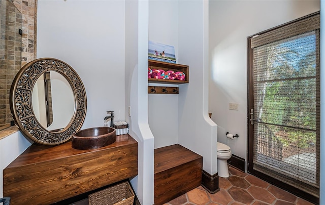 bathroom with a sink, toilet, and tile patterned floors