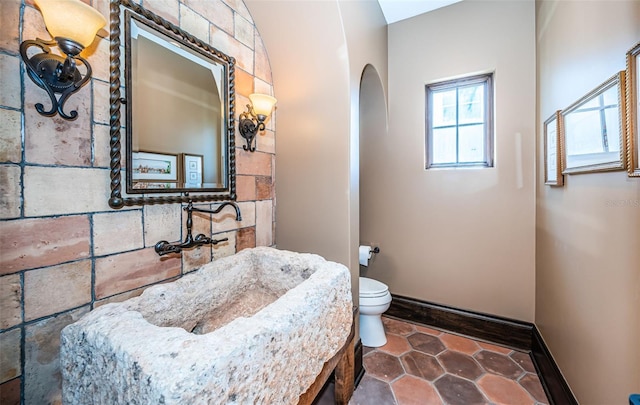 bathroom with toilet and baseboards