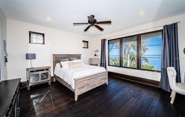 bedroom with ceiling fan, dark wood finished floors, and baseboards