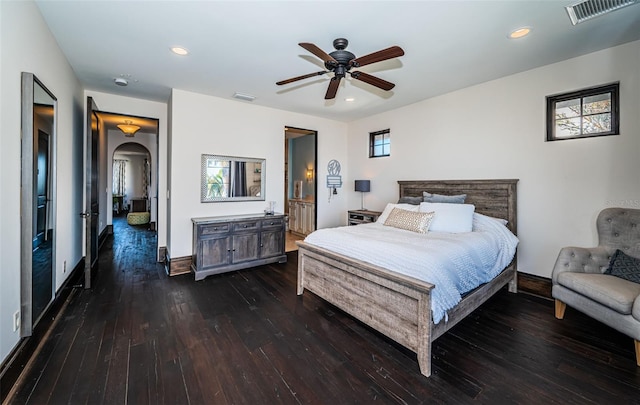 bedroom featuring arched walkways, dark wood-style flooring, visible vents, and recessed lighting