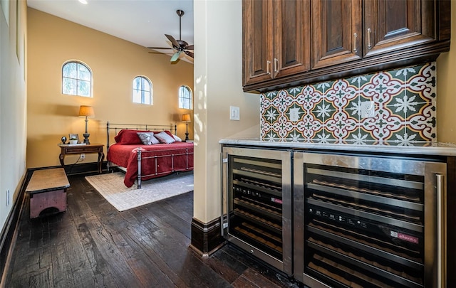 bedroom with beverage cooler, a bar, dark wood-type flooring, and baseboards