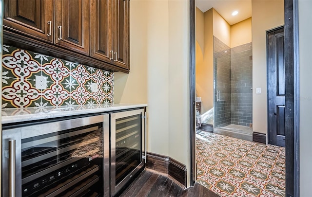 bar with wine cooler, a dry bar, and baseboards