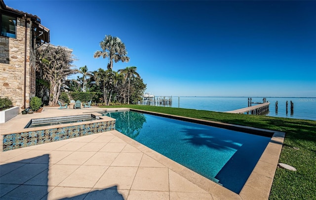 view of swimming pool featuring a water view, a pool with connected hot tub, and a lawn