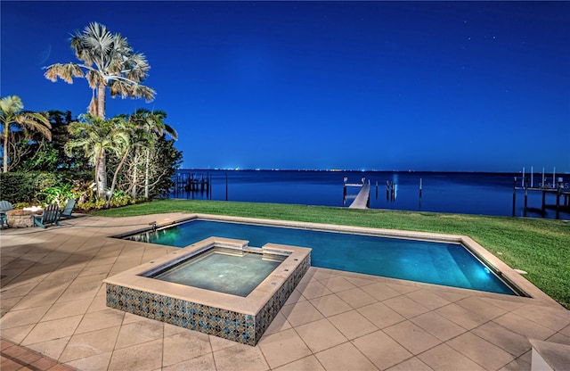 outdoor pool with a water view, a lawn, a patio, and an in ground hot tub