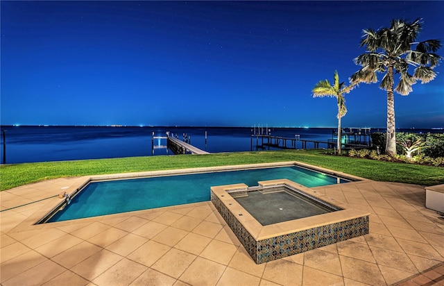 view of pool featuring an in ground hot tub, a yard, and a water view