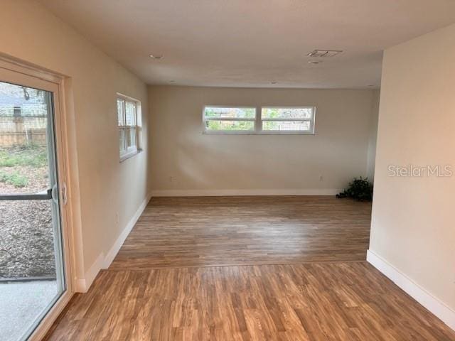 unfurnished room featuring hardwood / wood-style flooring and plenty of natural light