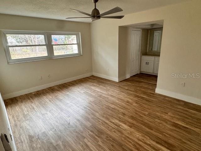 empty room featuring wood-type flooring and ceiling fan