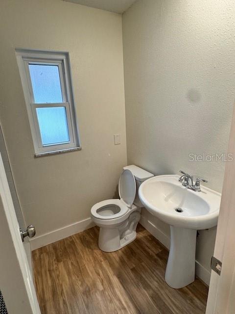 bathroom featuring hardwood / wood-style flooring and toilet