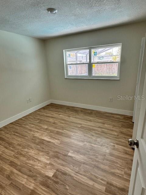 spare room with hardwood / wood-style floors and a textured ceiling