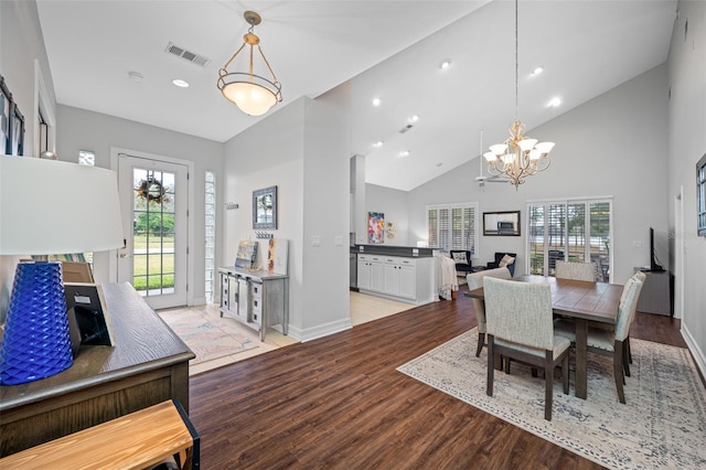 dining room featuring a notable chandelier, high vaulted ceiling, and light hardwood / wood-style floors