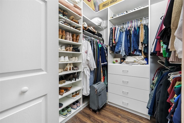 walk in closet with dark hardwood / wood-style flooring