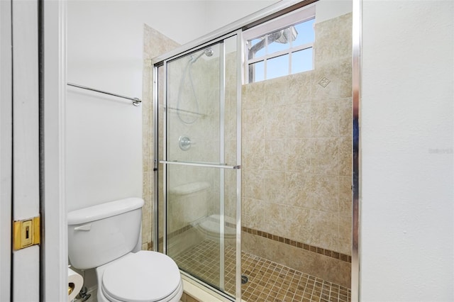 bathroom with toilet and an enclosed shower