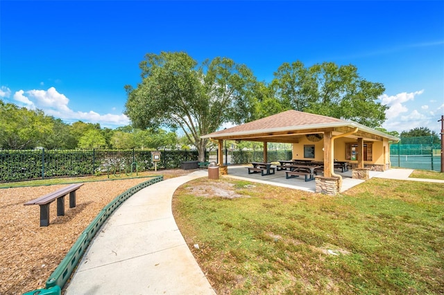 view of property's community featuring a yard and a patio