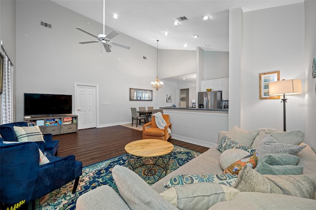 living room featuring a towering ceiling, ceiling fan with notable chandelier, and dark hardwood / wood-style floors