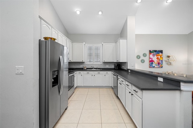 kitchen featuring kitchen peninsula, appliances with stainless steel finishes, sink, white cabinetry, and decorative backsplash