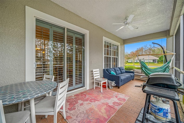 sunroom / solarium featuring ceiling fan