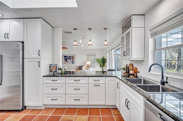 kitchen featuring light tile patterned flooring, sink, appliances with stainless steel finishes, pendant lighting, and white cabinets