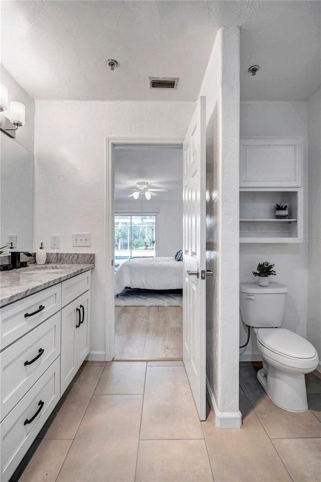 bathroom featuring tile patterned flooring, vanity, and toilet