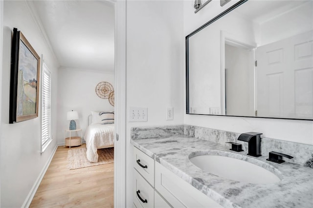 bathroom with hardwood / wood-style flooring, vanity, and crown molding