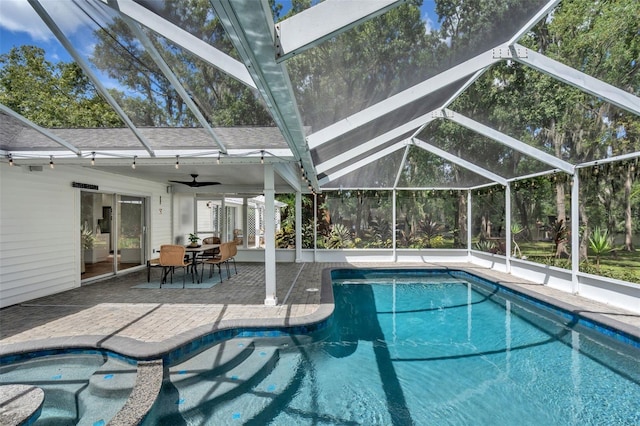 outdoor pool with a lanai, a ceiling fan, outdoor dining space, and a patio area