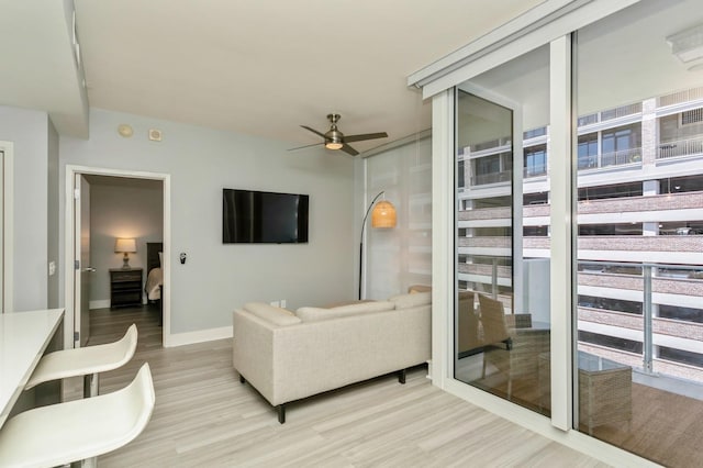 living room with ceiling fan and light hardwood / wood-style flooring