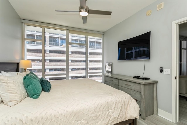 bedroom featuring multiple windows, light hardwood / wood-style flooring, and ceiling fan