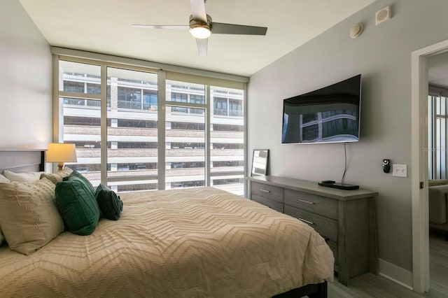 bedroom with a wall of windows, ceiling fan, and hardwood / wood-style floors