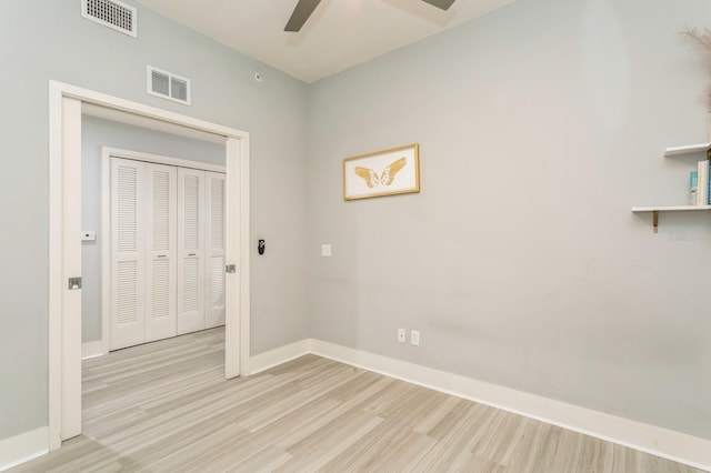 spare room with ceiling fan and light wood-type flooring