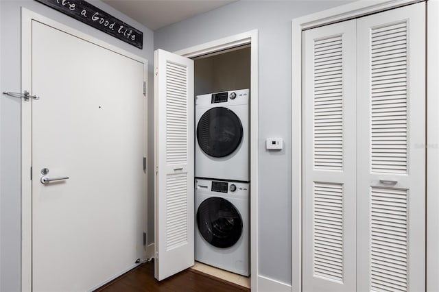 clothes washing area with stacked washer / dryer and dark hardwood / wood-style floors