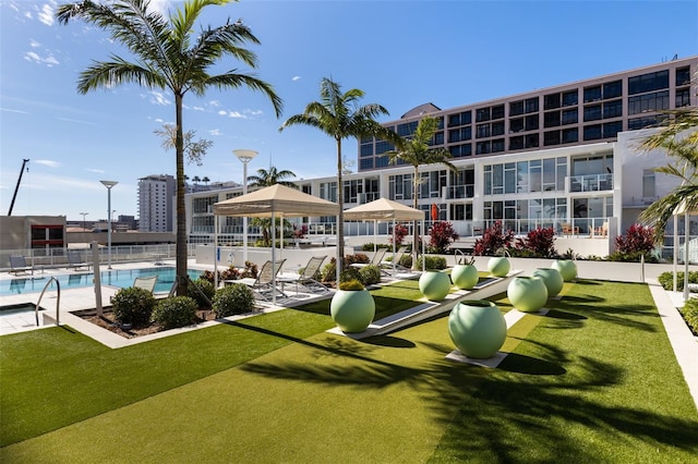 view of home's community featuring a swimming pool and a yard