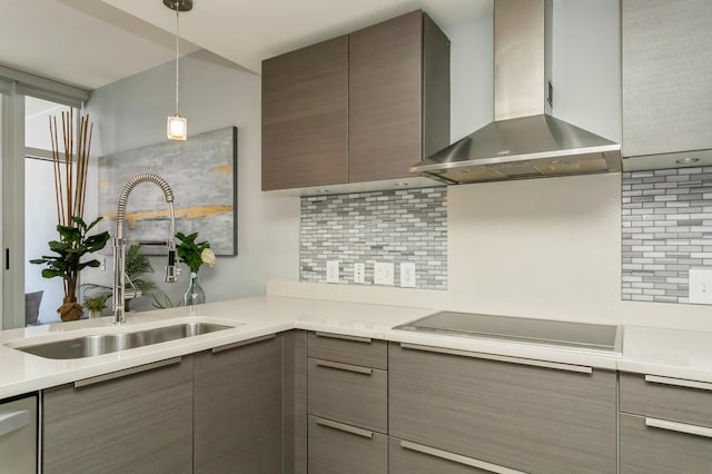 kitchen featuring tasteful backsplash, black electric stovetop, sink, and wall chimney range hood