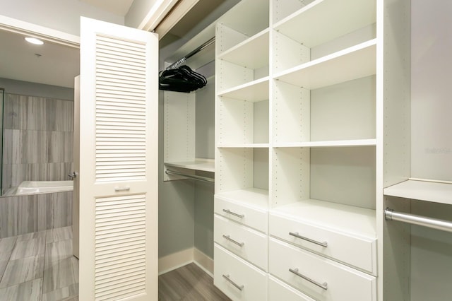 walk in closet with dark hardwood / wood-style floors