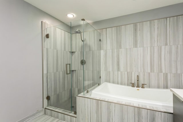 bathroom featuring vanity and independent shower and bath