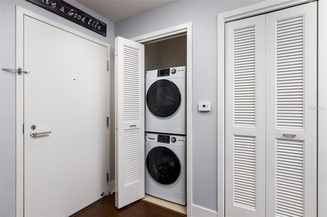 washroom featuring dark hardwood / wood-style flooring and stacked washer and dryer