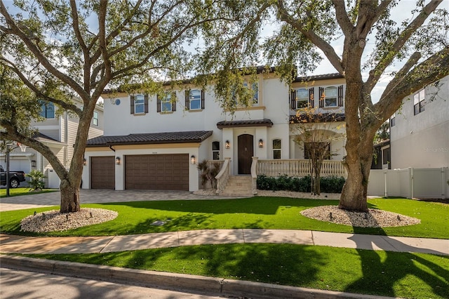 mediterranean / spanish house with a garage and a front lawn