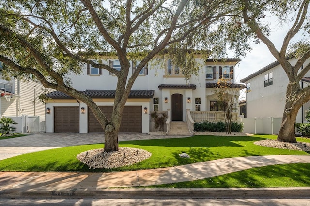 mediterranean / spanish-style home with a garage and a front lawn