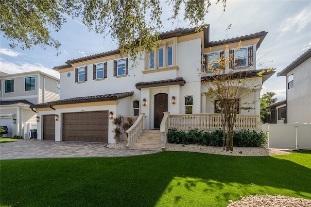 mediterranean / spanish home with a garage and a front lawn