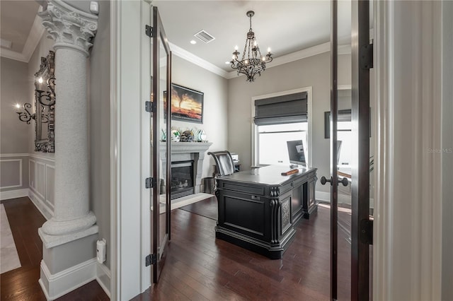 office space featuring dark wood-type flooring, ornamental molding, ornate columns, and a chandelier